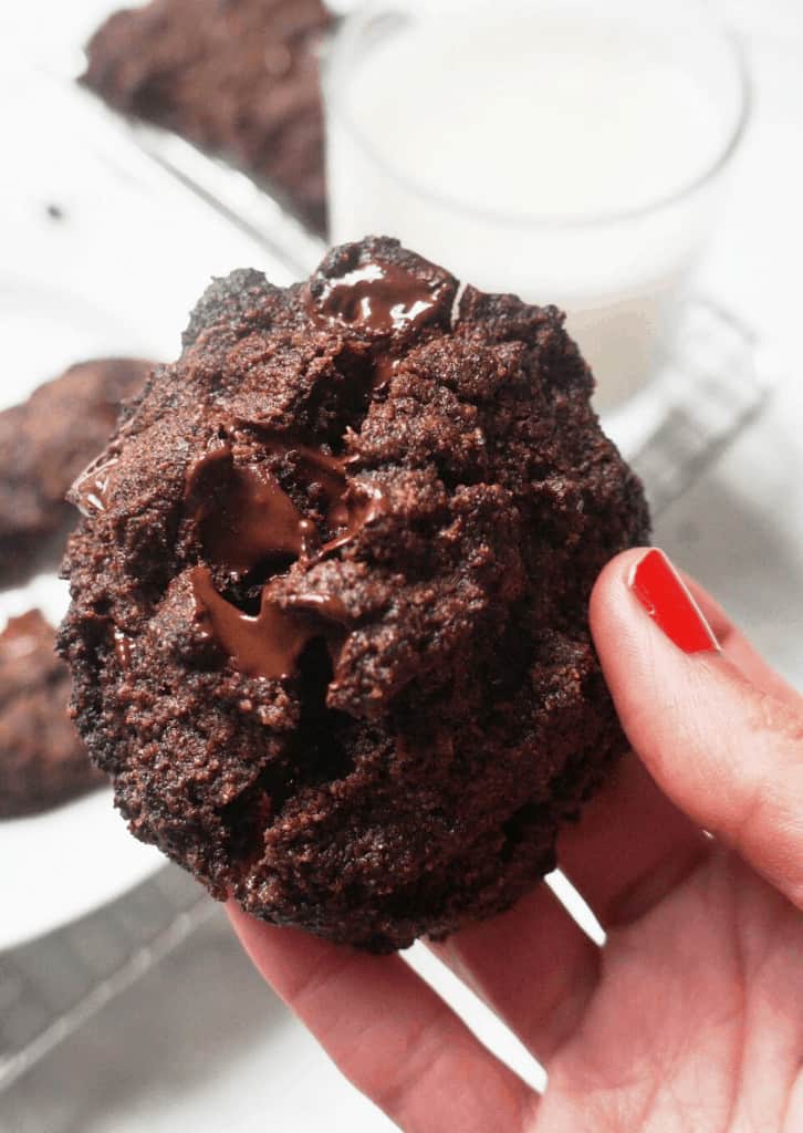 A woman's hand holding a Keto Double Chocolate Chip Cookie