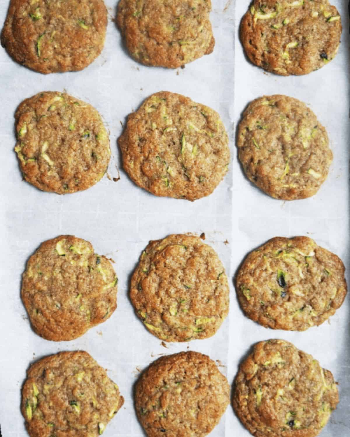 Twelve baked whoopie pie cookies out of the oven on parchment paper.