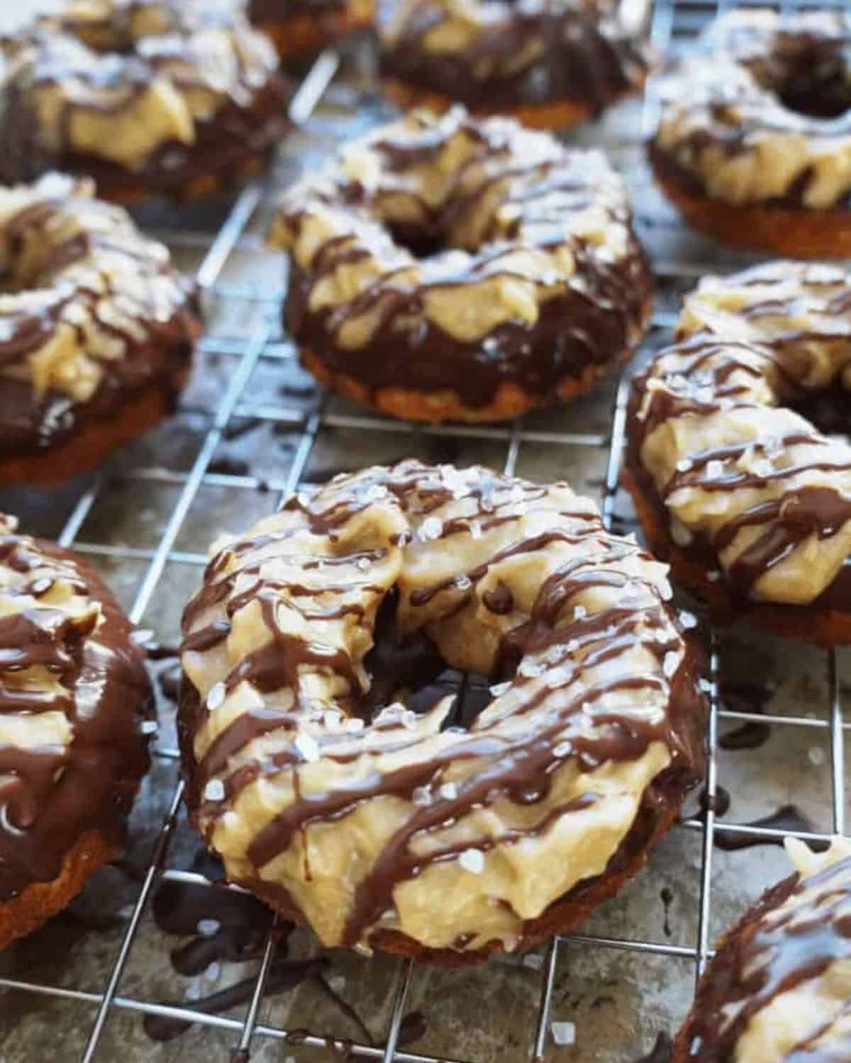 close up of samoa donuts on a wire rack next to other donuts