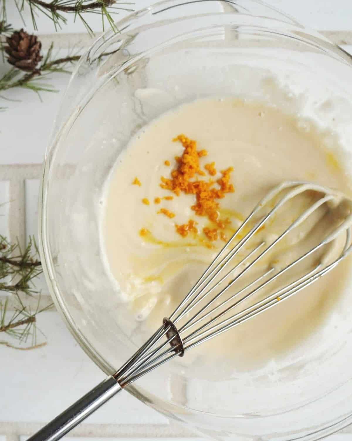 The icing being whisked together in a glass bowl.